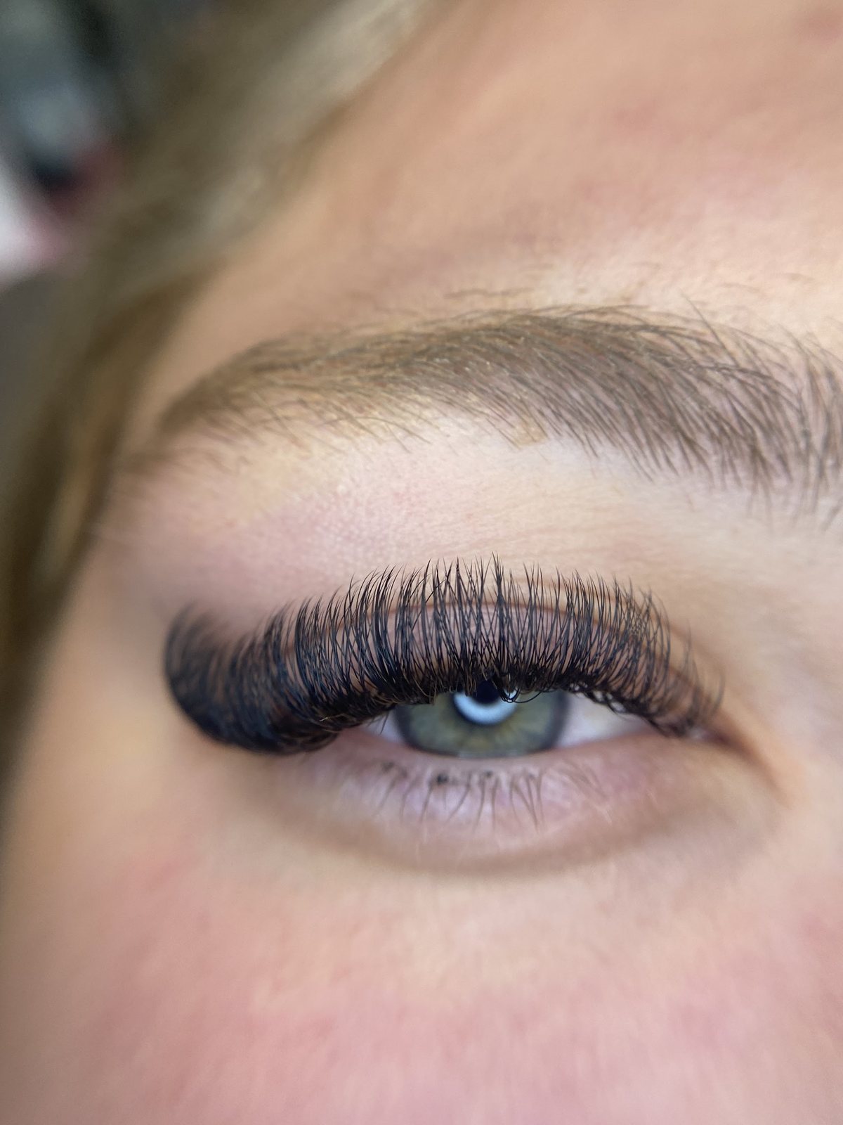 Close-up van een oog met een volle set wimperextensions